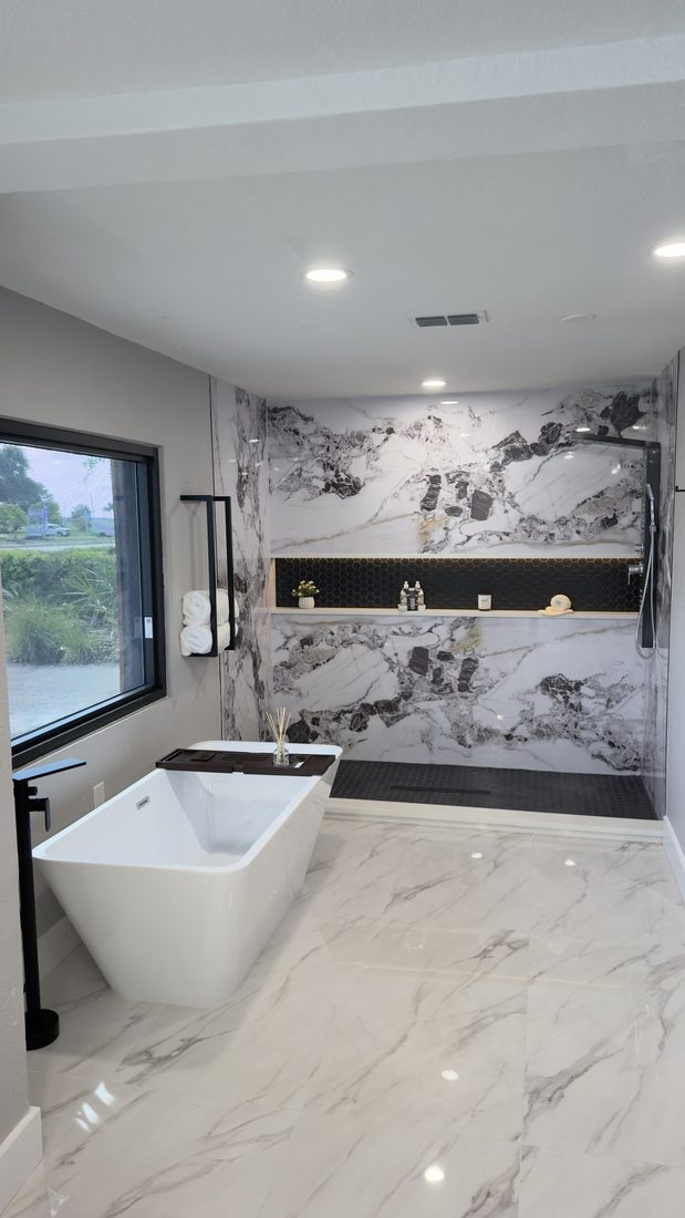 Primary bathroom with marble slab surround and freestanding tub