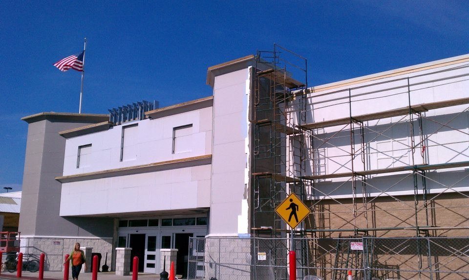Commercial building under construction with scaffolding along the facade and the tower element going up