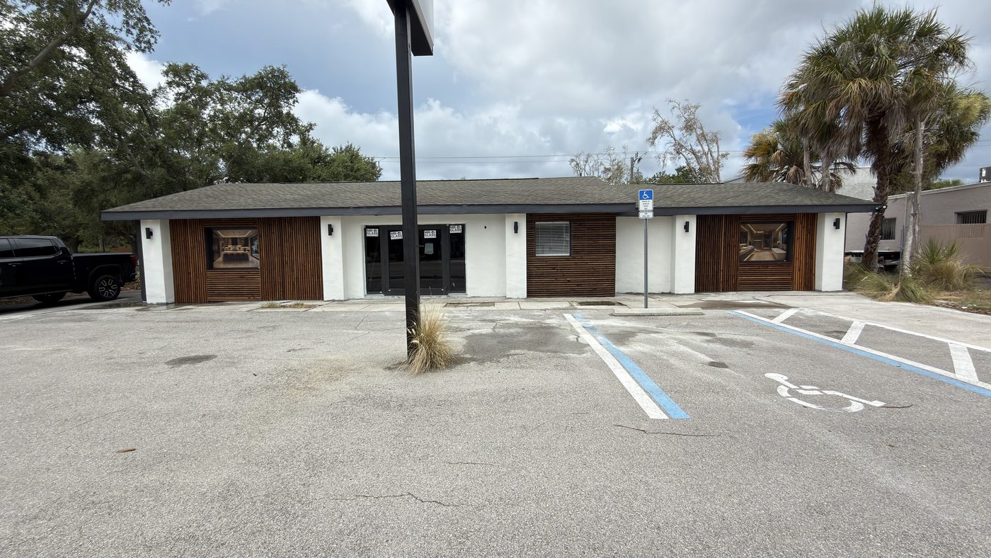 Completed commercial exterior renovation with new siding and entry
