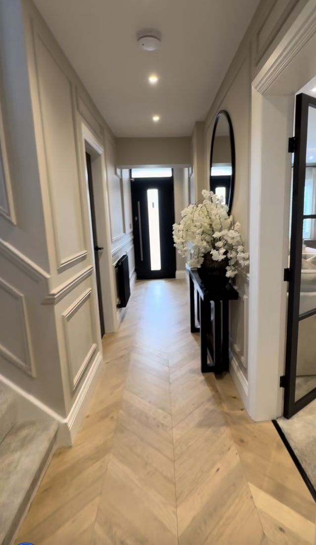 Renovated entry hallway with herringbone wood flooring